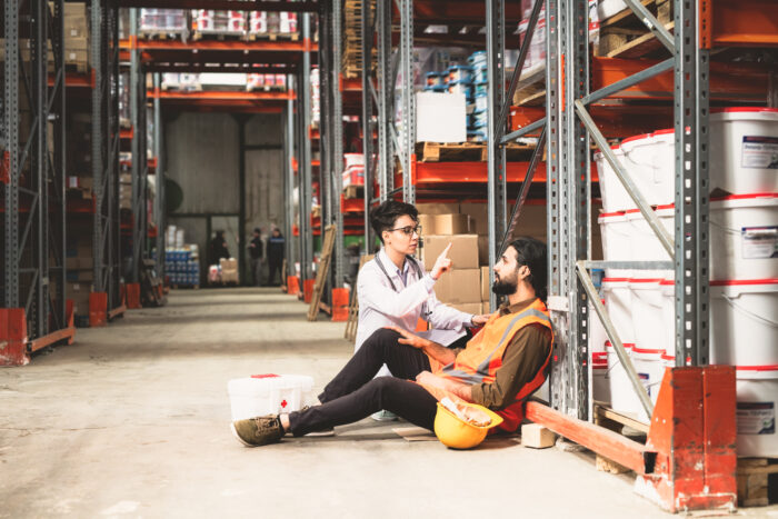 young-female-giving-first-aid-to-one-of-warehouse-workers